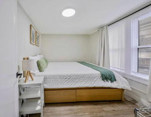 a small bedroom with a bed and a window at Charming & Bright Gem Prime Location Street Parking with AC in Renton