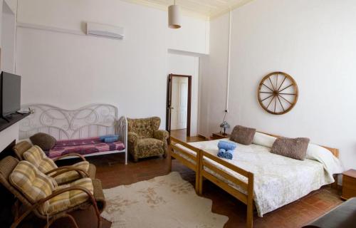 a bedroom with a bed and a couch and chairs at Palacete Dos Alcaides in Minas de São Domingos
