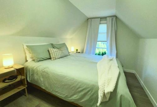a bedroom with a large bed with a window at Chic, Cozy & New Prime location with AC, Street Parking #4 in Renton