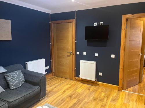 a living room with a couch and a flat screen tv at Cute Cottage Central Bathgate Inc Sofa Bed in Bathgate