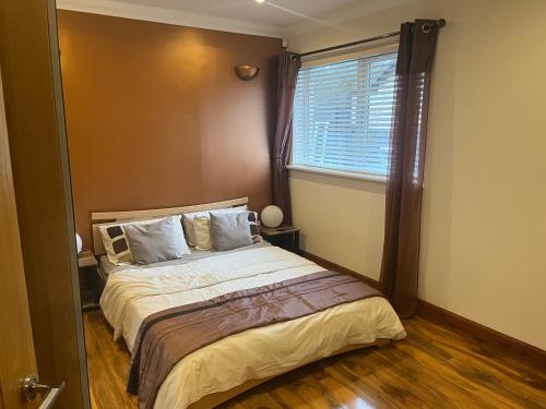 a bedroom with a large bed with a window at Cute Cottage Central Bathgate Inc Sofa Bed in Bathgate