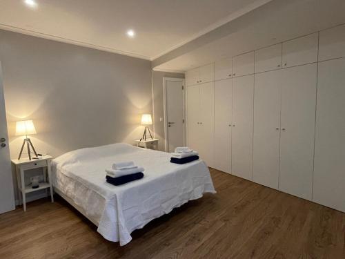 a bedroom with a white bed and white cabinets at Azorean Sunset Loft 1 in Ribeira Grande