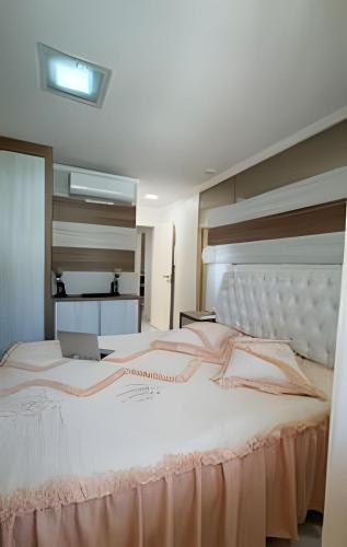a large white bed in a room with a window at Apto Antúrios|3Q. Sacada c/Churrasqueira in Piratuba