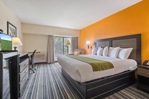 a hotel room with a large bed and a television at Crossroads Hotel and Huron Event Center in Huron