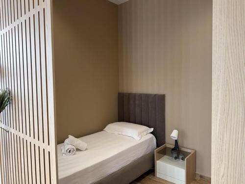 a small bedroom with a bed and a night stand at Elite Sunset Residence in Vlorë