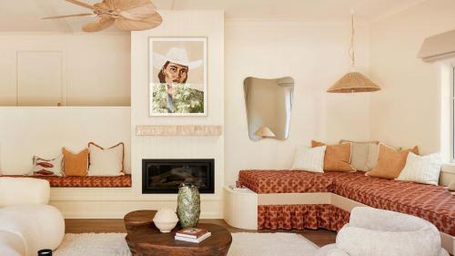 a living room with a bed and a fireplace at Designed By Three Birds Renovation in Pearl Beach