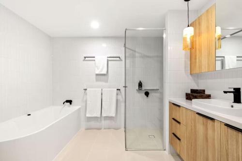 a white bathroom with a shower and a sink at THE COSMOPOLITAN COTTON TREE Unit 10207 Cotton Tree in Maroochydore