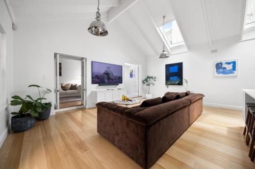 a living room with a large couch in the middle at Eastside Oasis - Heart of Norwood with Poolside Garden in Norwood