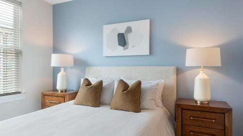 a bedroom with a white bed with two lamps at Landing Modern 2BD Gym Pool in Cornelius
