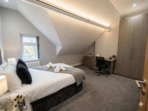 a bedroom with a bed and a desk and a window at Central 3 beds with parking in Reading