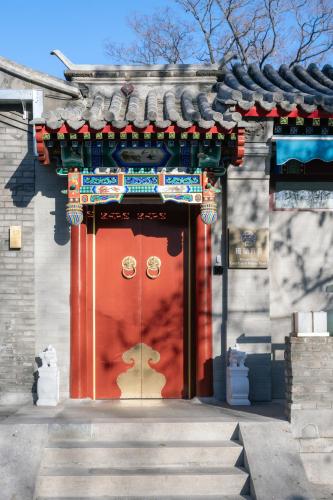 a red door of a building with a roof at Liuli Tile Courtyard Hotel Houhai Tian Anmen Wangfujing in Beijing