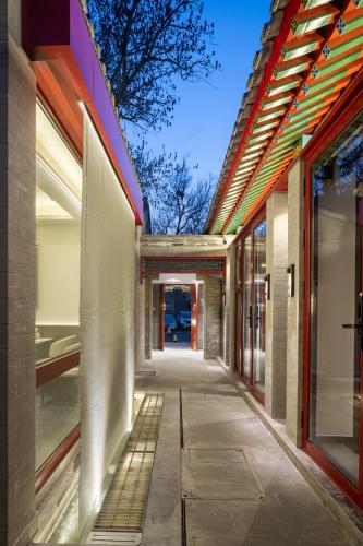 an empty hallway of a building with glass windows at Liuli Tile Courtyard Hotel Houhai Tian Anmen Wangfujing in Beijing