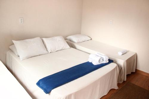 two beds in a small room with towels on them at Pousada - Árvore da Vida in Bonito