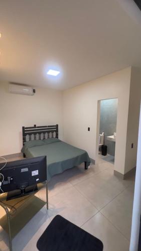 a bedroom with a bed and a tv in a room at Casa do Lago Serra da Mesa - Niquelandia in Niquelândia