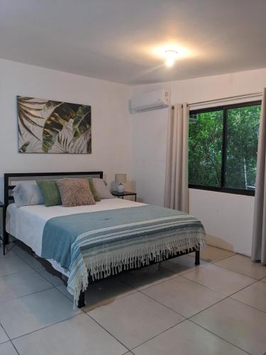 a bedroom with a bed and a large window at The Paradise Jungle Studio in Coco