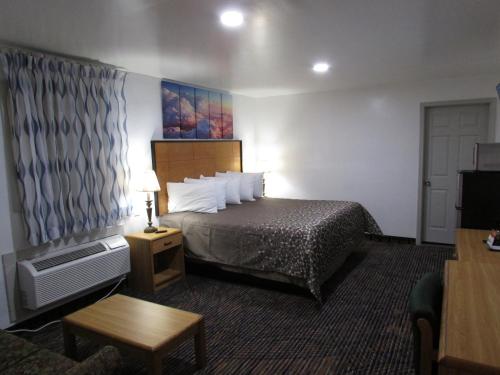 a hotel room with a bed and a tv at Parsons Inn Downtown Parsons,Tn in Parsons