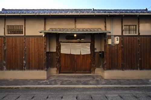 a building with a wooden door with a window at The Nomad Inn Yugejima in Kami-yuge