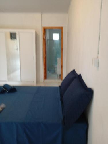 ein Schlafzimmer mit einem blauen Bett und einem Fenster in der Unterkunft Quarto suíte 2 in Itaqui