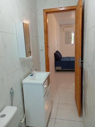 ein Badezimmer mit Toilette, Waschbecken und Tür in der Unterkunft Quarto suíte 2 in Itaqui