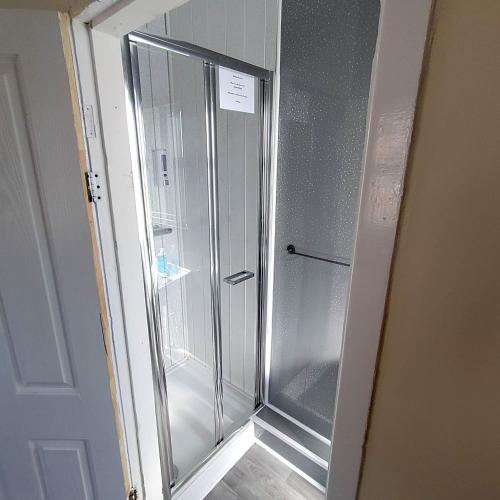 a glass shower in a room with a door at South Cliff Hotel in Blackpool