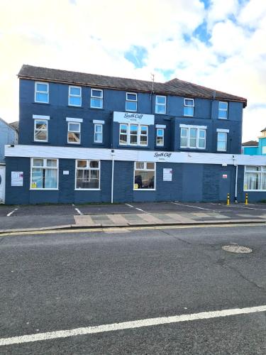 a blue building on the side of a street at South Cliff Hotel in Blackpool