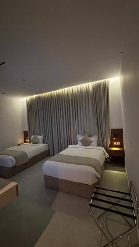 a hotel room with two beds and a window at الزاوية للشقق الفندقية in Medina