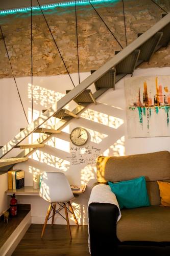 a living room with a couch and a clock on the wall at La Casica del Abuelo Valentín in Torreblascopedro