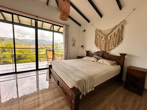 a bedroom with a bed and a large window at Finca Villa AlCon - Hostel in Pereira