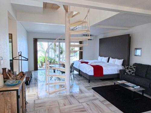a bedroom with a bed and a staircase in a room at abundance okinawa & Kourijima Sauna resort in Kouri