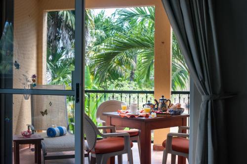a dining room with a table and a balcony at Abbey del Sol - Tropical Escape Near Beach in Puerto Morelos in Puerto Morelos