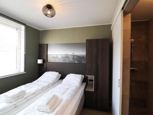 two beds in a room with green walls at Luxury waterfront villa in Leons