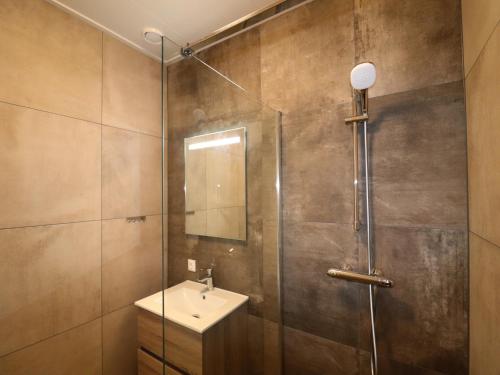 a bathroom with a shower with a sink and a mirror at Luxury waterfront villa in Leons