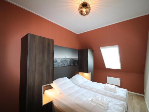 a bedroom with red walls and a bed with white sheets at Luxury waterfront villa in Leons