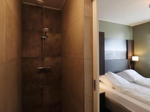 a bathroom with a shower and a bed in it at Luxury waterfront villa in Leons