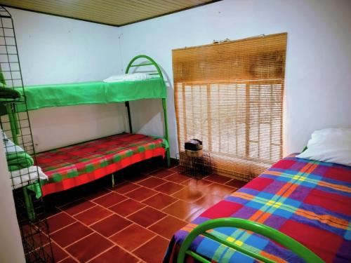 a room with two bunk beds and a window at Finca la Riverita in Sutamarchán