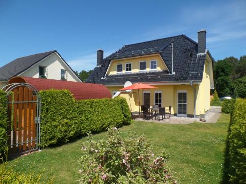 a house with a gate in the yard at Ferienhaus am Eikboom - DHH2 mit Fasssauna in Ostseebad Karlshagen