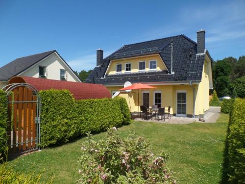 ein Haus mit einem Tor im Hof in der Unterkunft Ferienhaus am Eikboom - DHH2 mit Fasssauna in Ostseebad Karlshagen