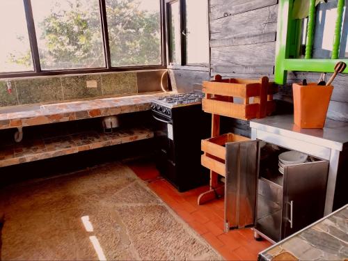 a kitchen with a stove and some windows at Finca la Riverita in Sutamarchán