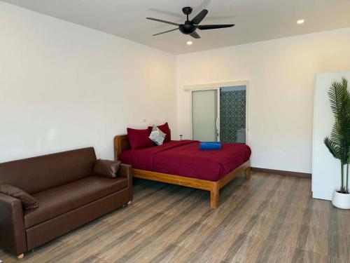 a living room with a bed and a couch at Roomz at Rawai in Ban Saiyuan (1)