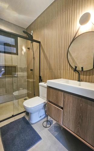 a bathroom with a toilet and a sink and a mirror at Studio moderno no centro de vinhedo in Vinhedo