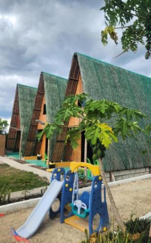 a playground with slides in front of a building at Nirvana bamboo houses & dive centre in Moalboal