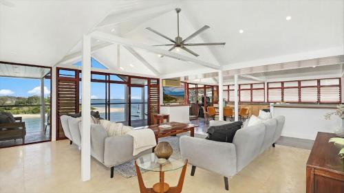 a living room with chairs and a ceiling fan at Sea Light in Currarong