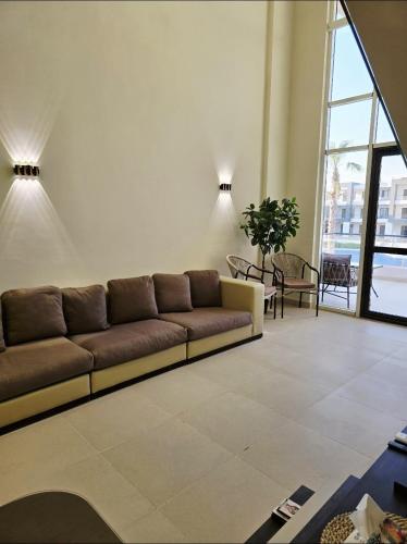 a living room with a couch and a large window at Luxury Azha Ain Sokhna Villa - Pool & Garden Views in Ain Sokhna