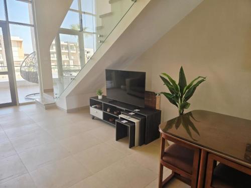 a living room with a flat screen tv and a table at Luxury Azha Ain Sokhna Villa - Pool & Garden Views in Ain Sokhna