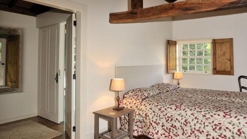 Un dormitorio con una cama y dos lámparas sobre una mesa. en Castelo Do Castro, en Carrazedo
