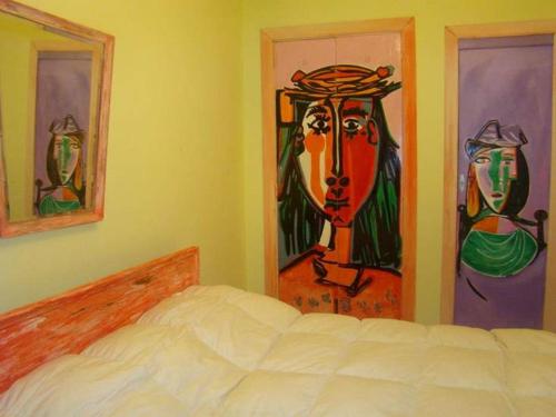 a bedroom with a bed and paintings on the walls at Hotel Elvines in Mar del Plata