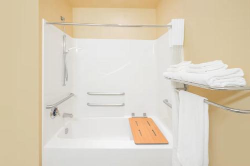a shower with a wooden sign in a bathroom at Microtel Inn & Suites by Wyndham Quincy Downtown - River Area in Quincy