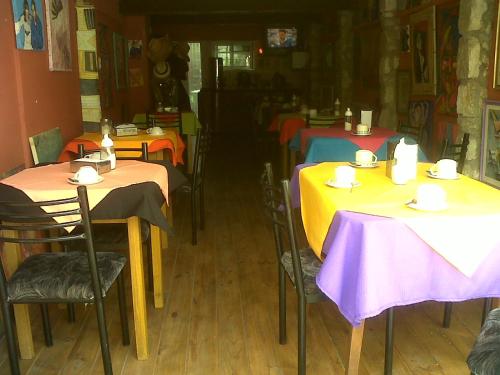 Hotel Elvines في مار ديل بلاتا: مطعم بطاولات وكراسي بطاولات صفراء وارجوانية
