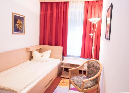a small room with a bed and a chair at Hotel Giesing in Munich