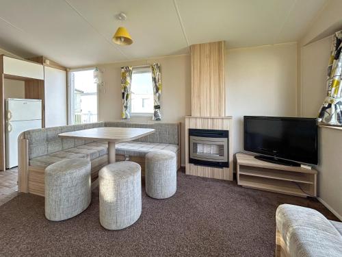 a living room with a table and a tv at The Rochester - Uk51003 in Eastchurch
